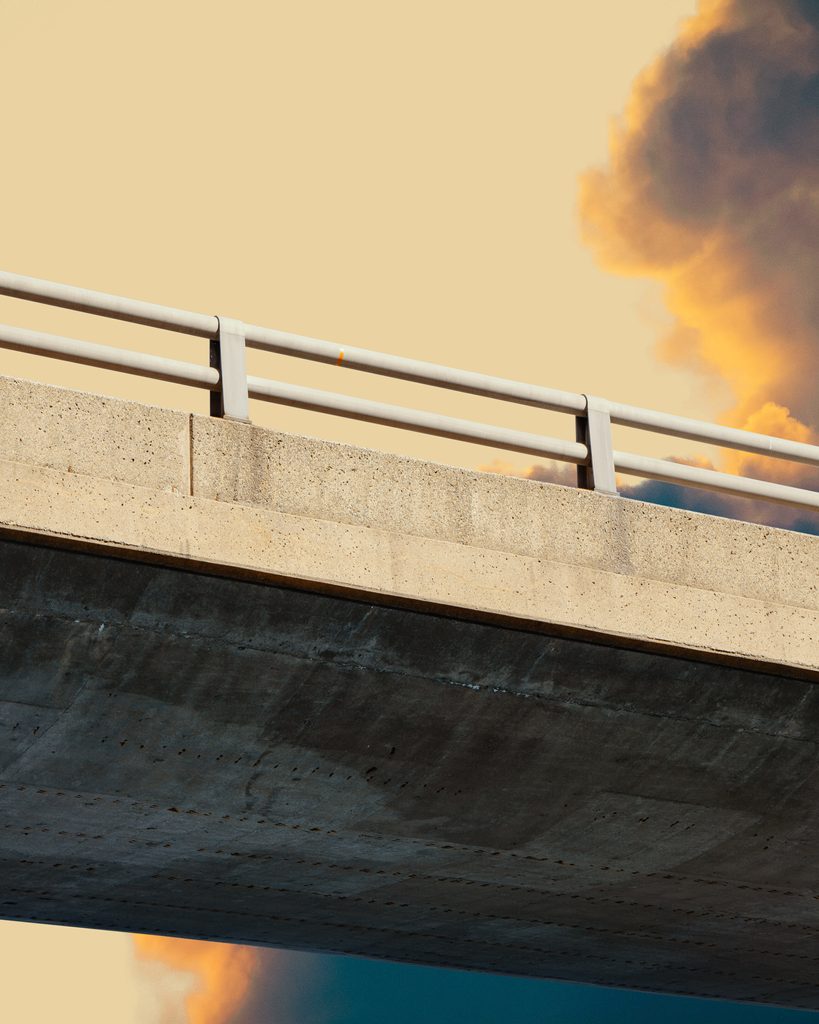 Autoroute brutaliste capturée dans une composition artistique, avec des jeux d'ombres créés par les formes géométriques du béton brut.