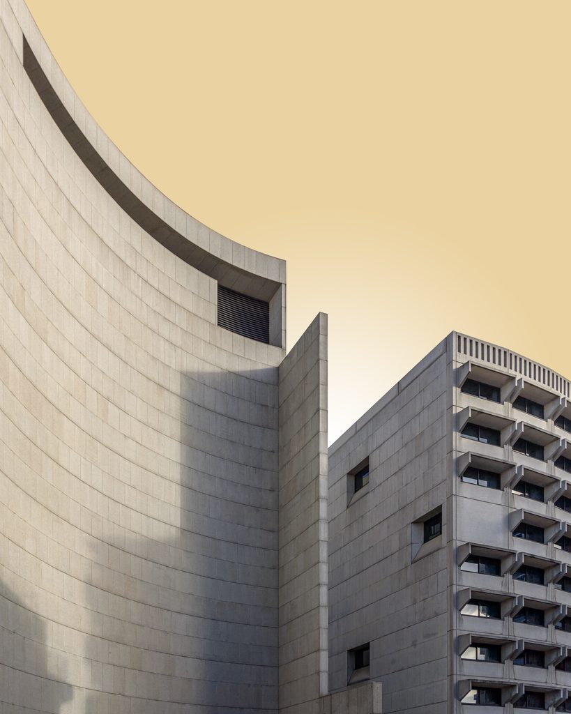 Photographie artistique mettant en avant les lignes géométriques d'une architecture brutaliste, capturée en détail pour exposer la beauté brute du matériau.